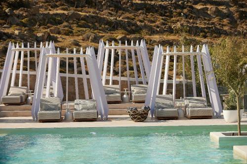 a set of white chairs and a pool at Once in Mykonos - Designed for Adults in Ornos