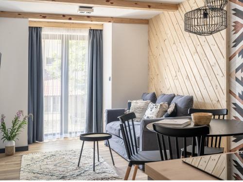 a living room with a couch and a table and chairs at Apartamenty Klemensówka in Zakopane
