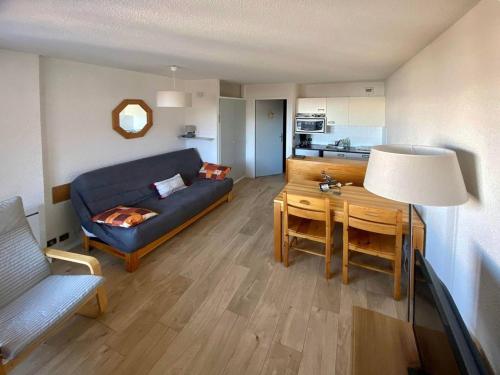 un salon avec un canapé bleu et une table dans l'établissement Studio au cœur des Orres pour 4 pers avec balcon, proche commerces et activités - FR-1-322-430, aux Orres