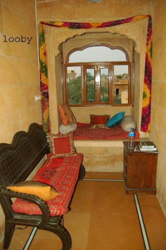 a room with a mirror and a couch and a chair at Hotel Pol Haveli Jaisalmer in Jaisalmer