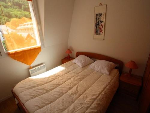 um quarto com uma cama e uma janela em Appartement Bagnères-de-Luchon, 2 pièces, 4 personnes - FR-1-313-135 em Luchon