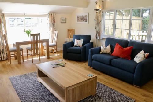 - un salon avec deux canapés bleus et une table basse dans l'établissement Lawnside 1, à Budleigh Salterton