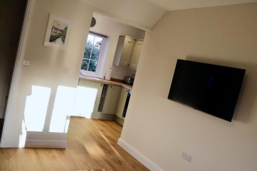 a living room with a flat screen tv on a wall at Lawnside 1 in Budleigh Salterton