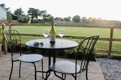 a table with two chairs and a bottle of wine at Lawnside 1 in Budleigh Salterton