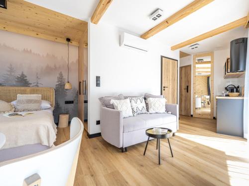 a living room with a bed and a couch at Apartamenty Klemensówka in Zakopane