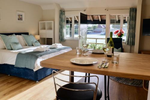 1 dormitorio con cama, mesa y comedor en Lawnside 2, en Budleigh Salterton