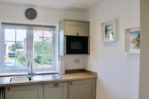 cocina con fregadero y ventana en Lawnside 3, en Budleigh Salterton