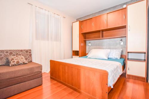 1 dormitorio pequeño con 1 cama y 1 silla en Apartments Yelkouan, en Biograd na Moru
