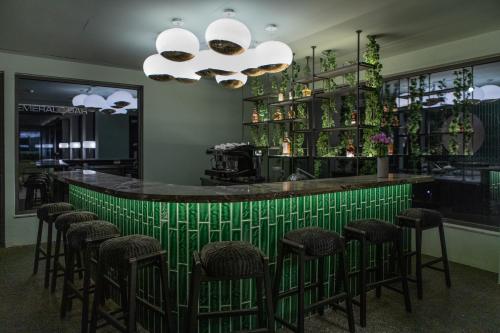 a green bar with stools in a restaurant at Cayo Exclusive Resort & Spa in Elounda