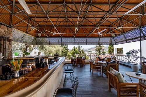 un ristorante con bar, tavoli e sedie di Manzara Boutique Hotel - Adults Only a Bodrum City