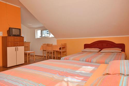 a bedroom with two beds and a kitchen with a table at Apartments Kujacic in Herceg-Novi