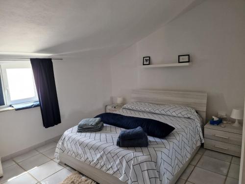 1 dormitorio con 1 cama con 2 almohadas en Appartamento nella piazza centrale, con terrazza, en SantʼAntìoco