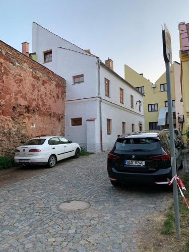 two cars parked on a street next to a building at Apartmány Zámecká in Moravská Třebová