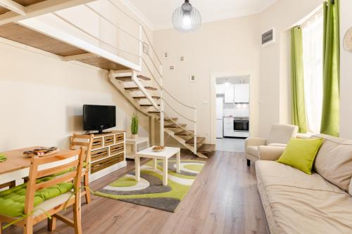 sala de estar con sofá y escalera en Downtown Greenie Home en Budapest