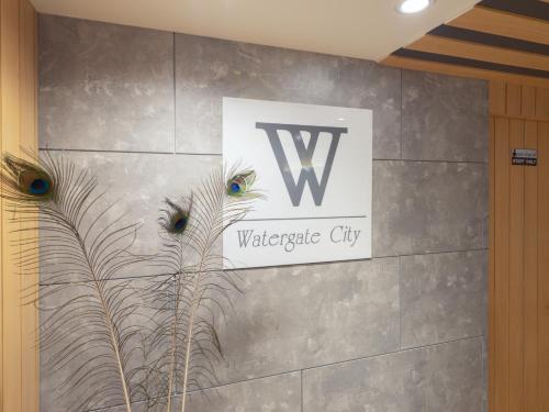 a sign with two peacocks on a wall at Watergate City in Bangkok