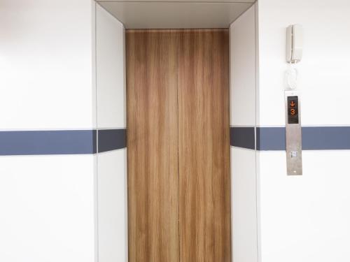 a wooden door in a room with white walls at Watergate City in Bangkok