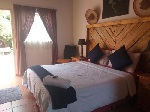 a bedroom with a large bed with a wooden headboard at 1010 Clifton bnb in Centurion