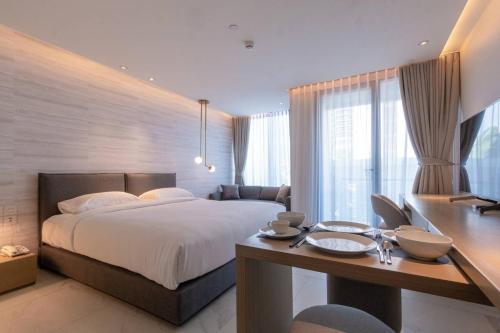 a bedroom with a large bed and a desk with a desk at ashley hotel bkk in Bangkok