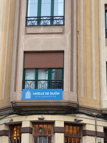 un edificio con un cartel que lee Mobile de guzman en Alojamientos Muelle de Gijón, en Gijón