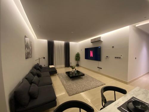 a living room with a couch and a flat screen tv at 3 - Bedroom Apartment in Riyadh