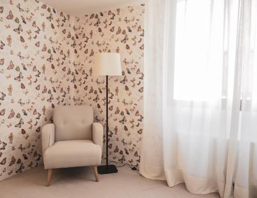 a chair and a lamp in a room with wallpaper at Hotel Oriente in Zaragoza
