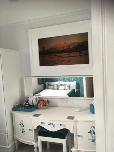 a bedroom with a desk with a bed in the background at Loggans Lodge in Hayle