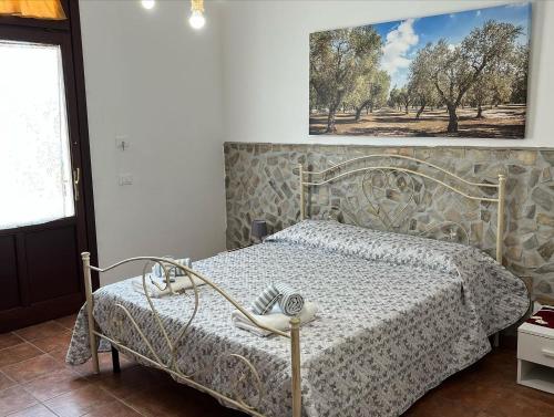 ein Schlafzimmer mit einem Bett und einem Bild an der Wand in der Unterkunft EL PAVINO Agriturismo Ristorante Pizzeria Alloggi in Porticalazzo