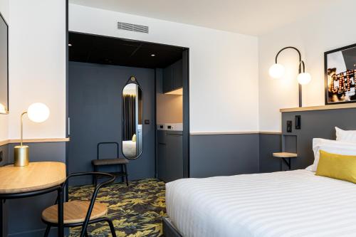 a hotel room with a bed and a table at Best Western M-Treize Paris Asnieres in Asnières-sur-Seine