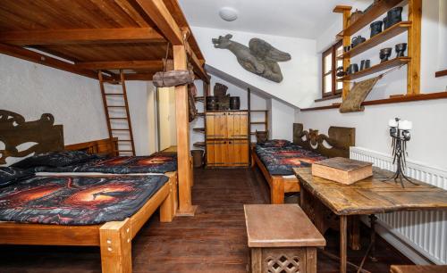 a room with three beds and a table at Housův Mlýn in Tábor
