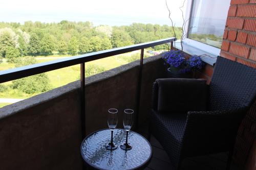 two wine glasses sitting on a table on a balcony at Baltic Sunset Apartments in Sillamäe
