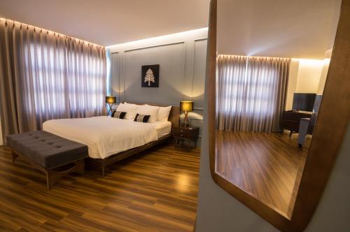 una camera con un grande letto e uno specchio di Danang Boutique Hotel a Da Nang