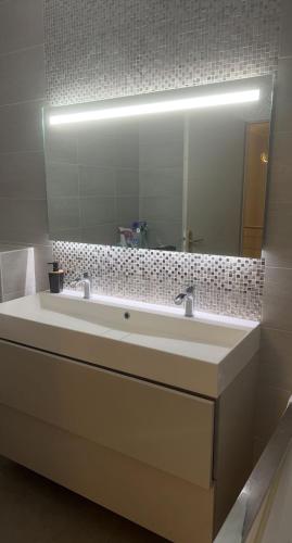 une salle de bain avec un lavabo et un grand miroir dans l'établissement Maison avec Picine, à Perpignan