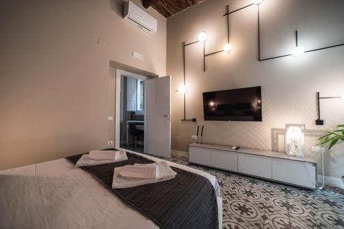 a bedroom with a large bed and a flat screen tv at Palazzo Paladini - Luxury Suites in the Heart of the Old Town in Pizzo