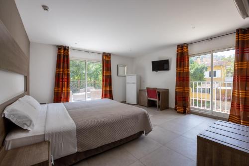 a bedroom with a bed and a large window at The Originals City, Hôtel Les Bastides du Gapeau in Solliès-Toucas