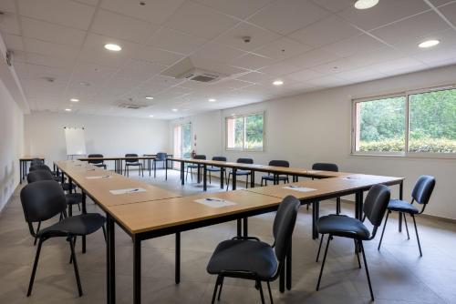 a large room with tables and chairs in it at The Originals City, Hôtel Les Bastides du Gapeau in Solliès-Toucas