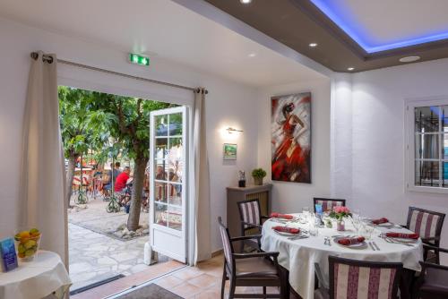 a dining room with a table and chairs at The Originals City, Hôtel Les Bastides du Gapeau in Solliès-Toucas