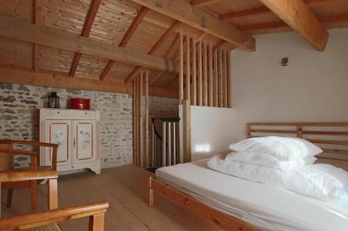 um quarto com uma cama branca num quarto com tectos em madeira em Elma Stay Location LAlbatros em Saint-Pierre-dʼOléron
