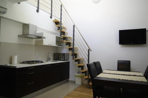 a kitchen with a staircase and a table and a kitchen with a dining room at Apartments Santis10 in Baška
