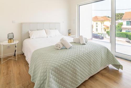 ein Schlafzimmer mit einem großen Bett mit Handtüchern darauf in der Unterkunft Villa Cuca in Aroeira