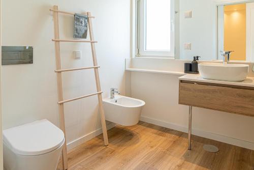 ein Badezimmer mit einer weißen Toilette und einem Waschbecken in der Unterkunft Villa Cuca in Aroeira