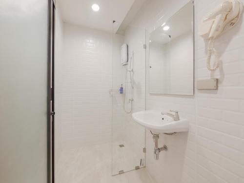 a white bathroom with a shower and a sink at Watergate City in Bangkok