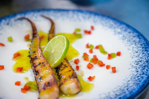 a plate of food with shrimp and a lime at Effect Algara Beach Resort - Ultra All Inclusive and Free Parking in Kranevo