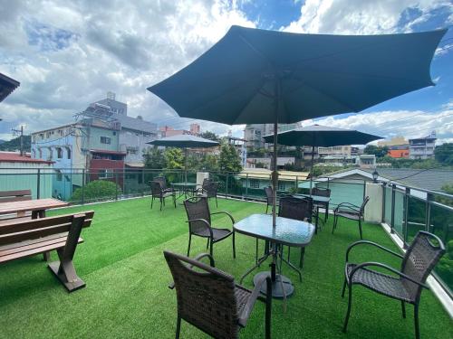 a patio with a table and chairs and an umbrella at Red brick 642 B&B in Puli