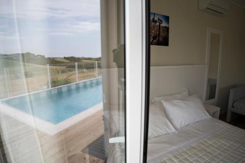 a bedroom with a bed next to a swimming pool at Balconi Del Conero in Numana