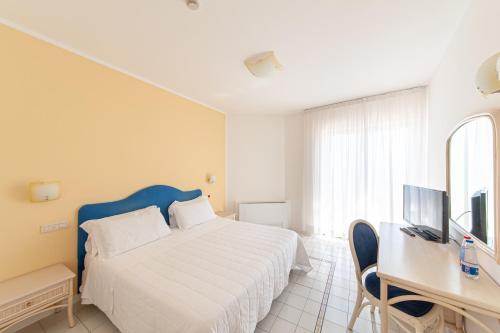 a bedroom with a bed and a desk and a television at Hotel Club Due Torri in Maiori