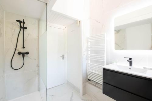 Un baño blanco con lavabo y ducha. en Villa Les Glycines, en Les Issambres