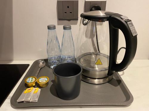 un vassoio con 2 bottiglie d'acqua e una macchinetta del caffè di 3 - Bedroom Apartment a Riyad