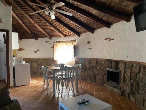 a living room with a table and a fireplace at complejo rural el prado in Logrosán
