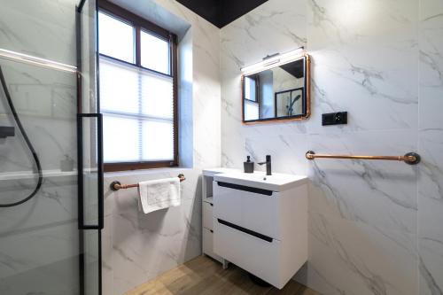 a white bathroom with a sink and a shower at Apartament Liściasty 1 z tarasem - Dream Apart in Ustroń