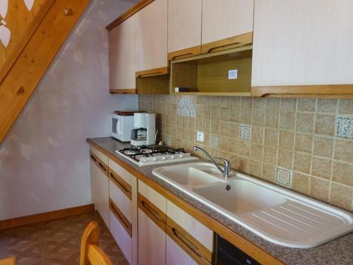 une cuisine avec un évier et un micro-ondes dans l'établissement Duplex 7 pers 2 étoiles, pied des pistes et randonnées, parking, balcon, WiFi optionnel - FR-1-342-202, à Beaufort
